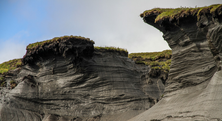 Alfred-Wegener-Institut | Jaroslav Obu | Canada: Sun, wind and waves gnaw at the cliffs of Herschel Island. Wherever the ice in the soil thaws, mudslides wash massive quantities of sod, humus and loose rock out to sea. As a result, the coastline is receding by several metres every year.