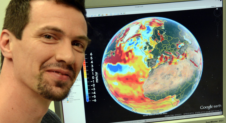 Johannes Seiler/Uni Bonn | Dr.-Ing. Roelof Rietbroek vom Institut für Geodäsie und Geoinformation der Universität Bonn mit einer globalen Darstellung des Meeresspiegelanstiegs am Computer-Bildschirm. Die verschiedenen Farben bedeuten unterschiedliche Niveaus.