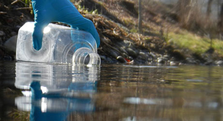 uzh.ch | Sampling of 1 liter of river water, in order to subsequently extract DNA from the organisms living in the river.