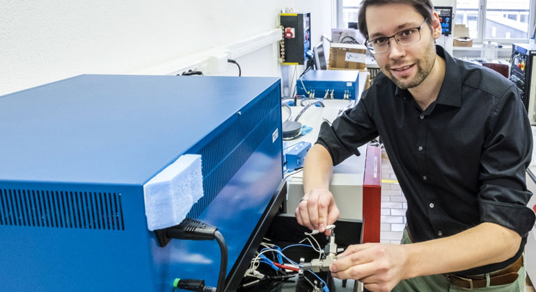 Empa.ch | Research on the water electrolyte: Empa researcher Ruben-Simon Kühnel connecting a test cell to the charger with the concentrated saline solution. The stability of the system is determined in several charging and discharging cycles.