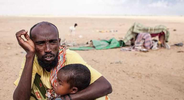 Thomas Rommel / Welthungerhilfe | Ein erschöpfter Mann mit Kind während einer Dürre in Somaliland.